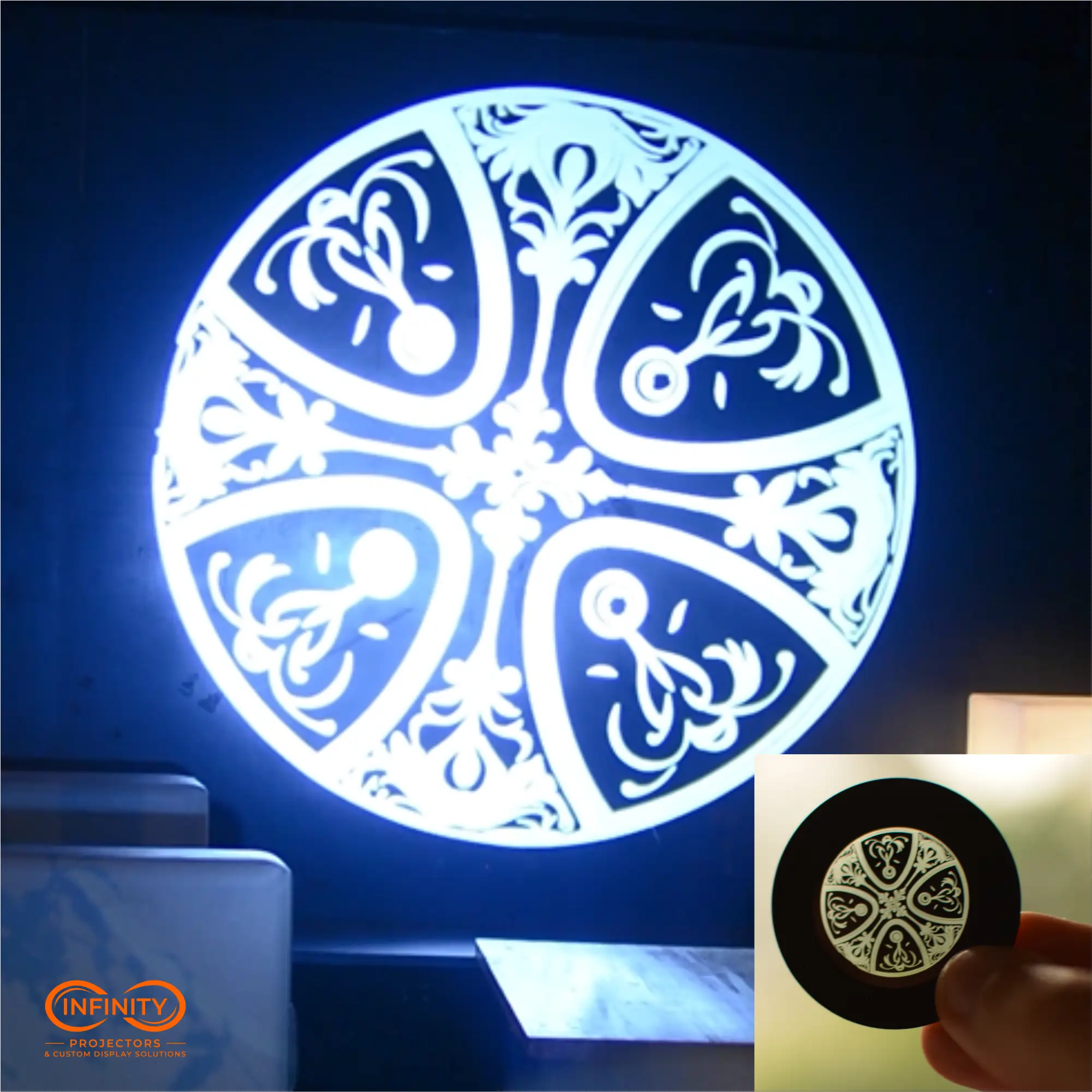 One-color ornamental gobo slide and its crisp white projection from a logo projector on a dark wall