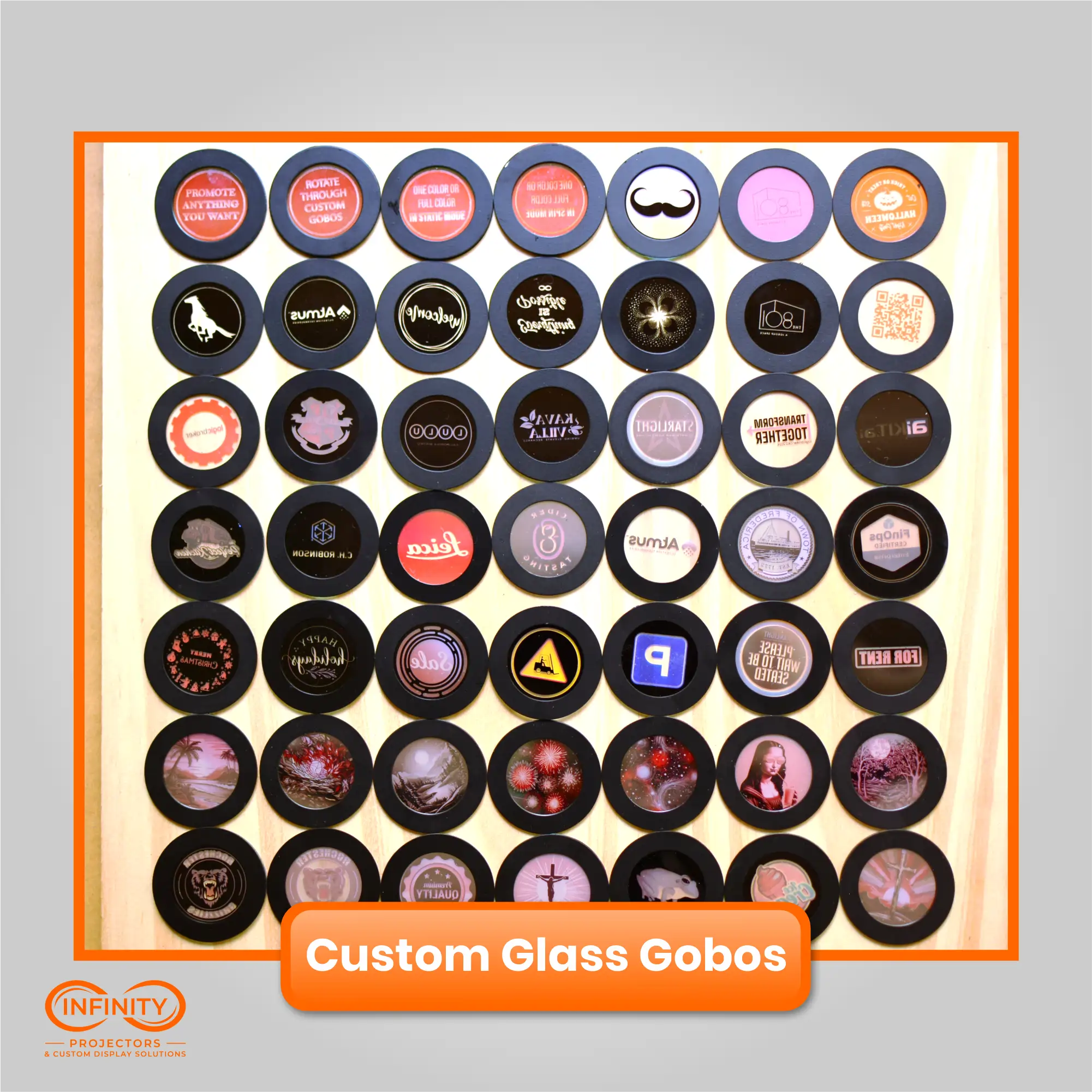 Wall of dozens of finished custom glass gobos showing client logos, signs, and full-color designs