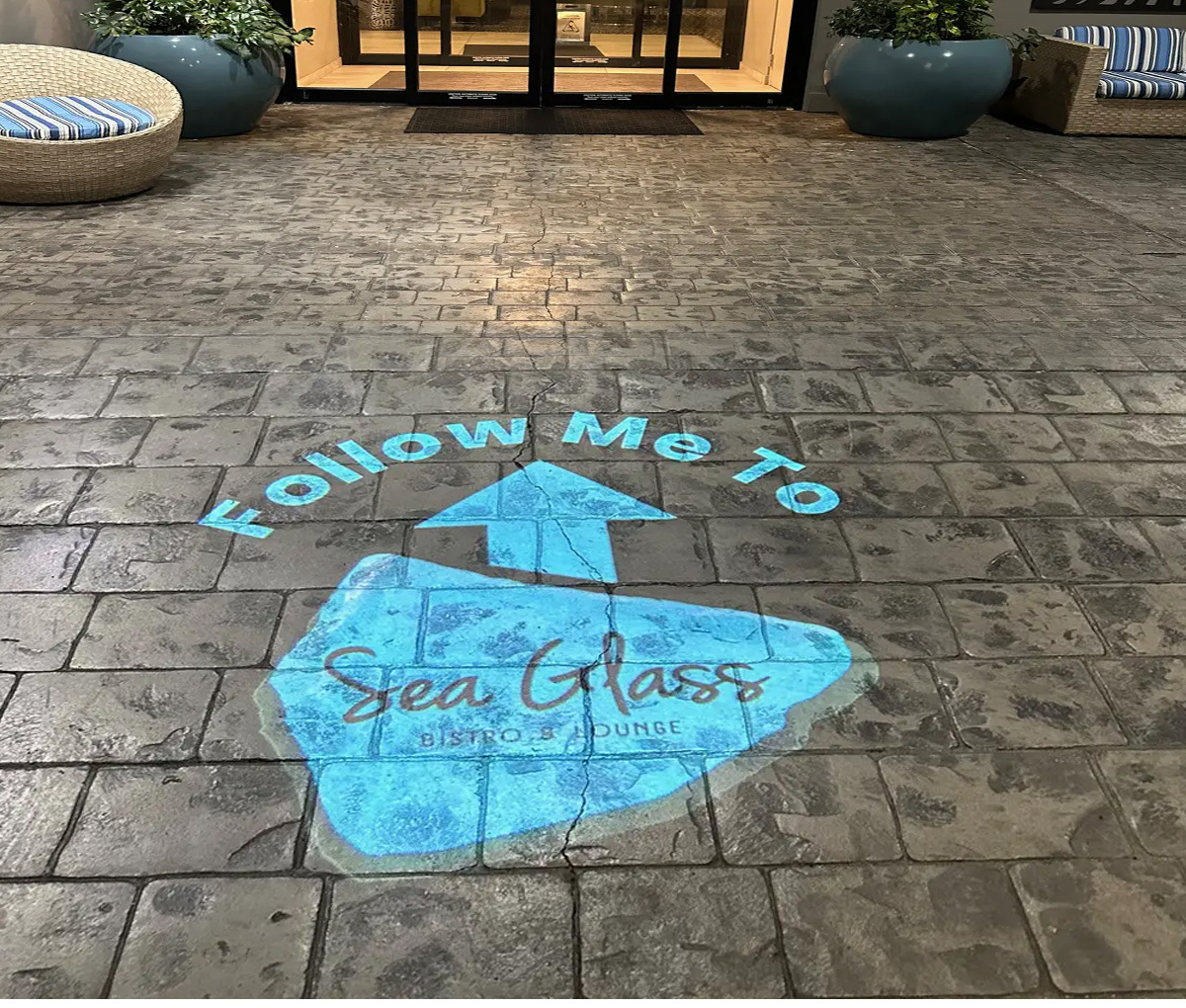Hero Crop Sidewalk Follow Me Arrow logo gobo projection — real Business & Branding install | Infinity Projectors