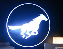 Video: white galloping horse emblem projected in a circle on a lounge wall between sofas