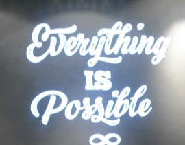 Video: white script quote Everything is Possible with infinity symbol on a dark wall