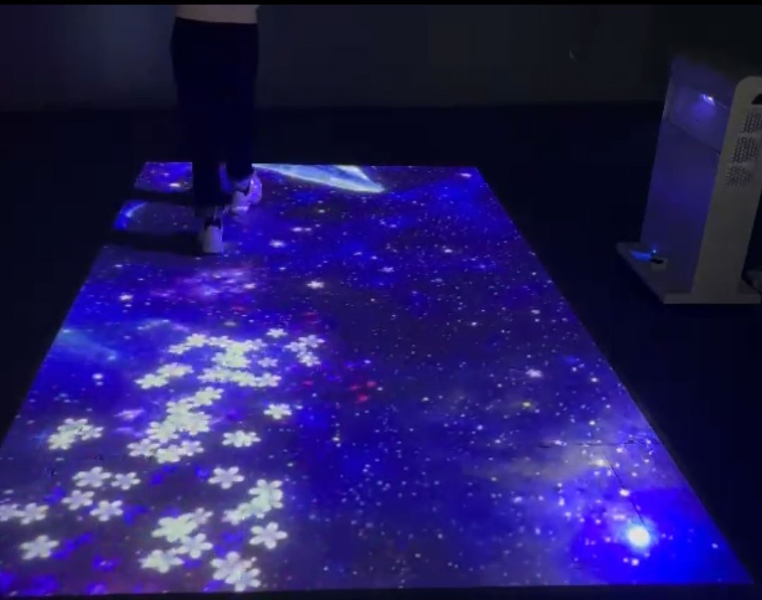 Video: mobile tower casts a starry galaxy floor where footsteps scatter white blossoms