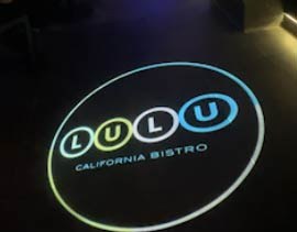 Video: colorful bistro logo circle projected on a dark restaurant floor