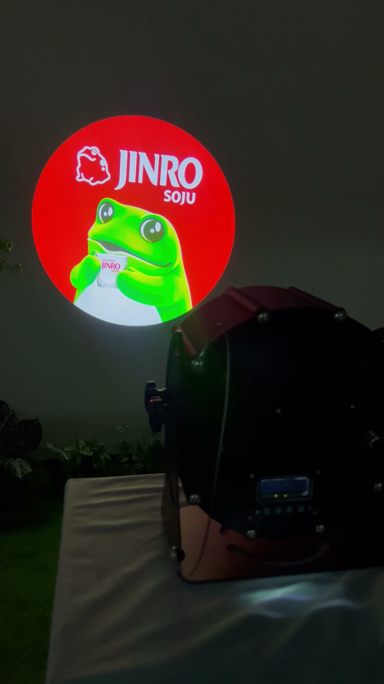 Jinro Soju logo gobo projected on a real sidewalk outside a store at night — Infinity Projectors