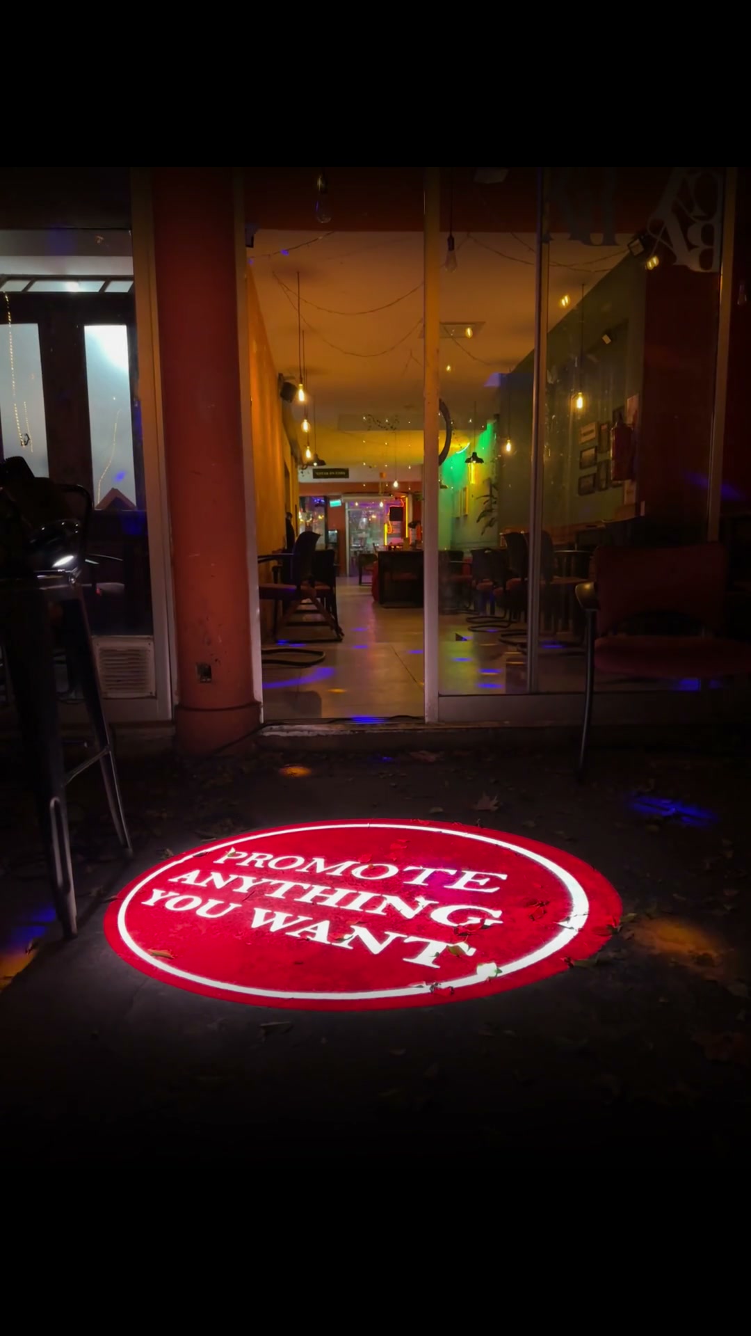 8 Gobo Spin Projector - logo on a storefront pavement at night, real install — Infinity Projectors