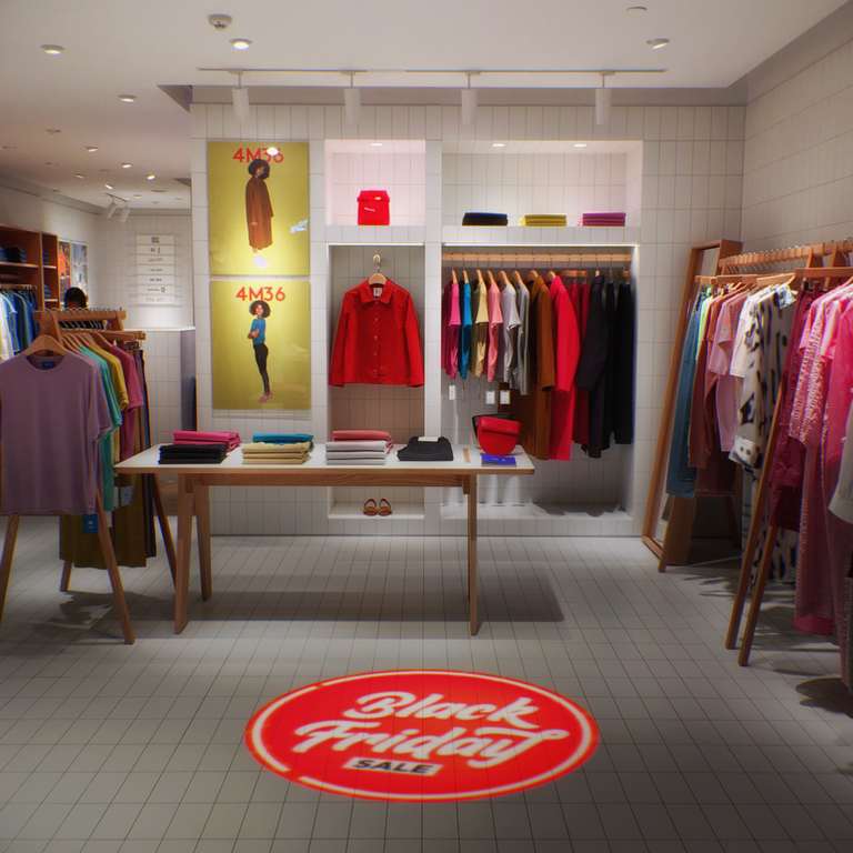 Red Black Friday sale floor projection on the tiles of a clothing boutique near racks of apparel — Infinity Projectors