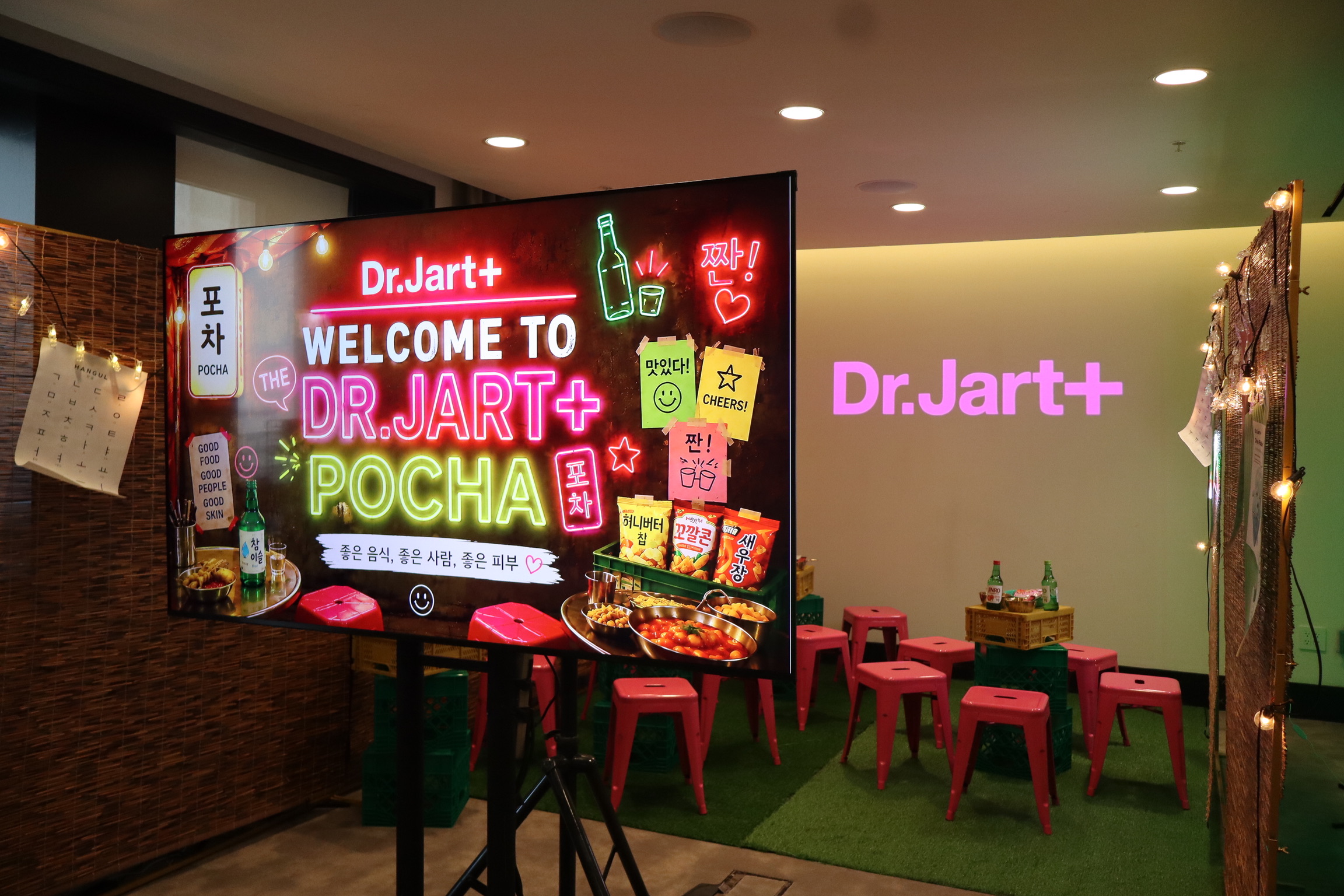 Dr. Jart+ logo projected on a wall beside the "Welcome to Dr. Jart+ Pocha" event screen — Infinity Projectors