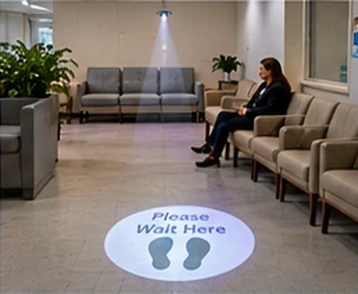 Waiting room with Please Wait Here and two footprints projected in a white circle on the floor — Infinity Projectors