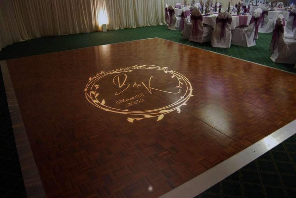 real photo of monogram projected on wood dance floor — Infinity Projectors