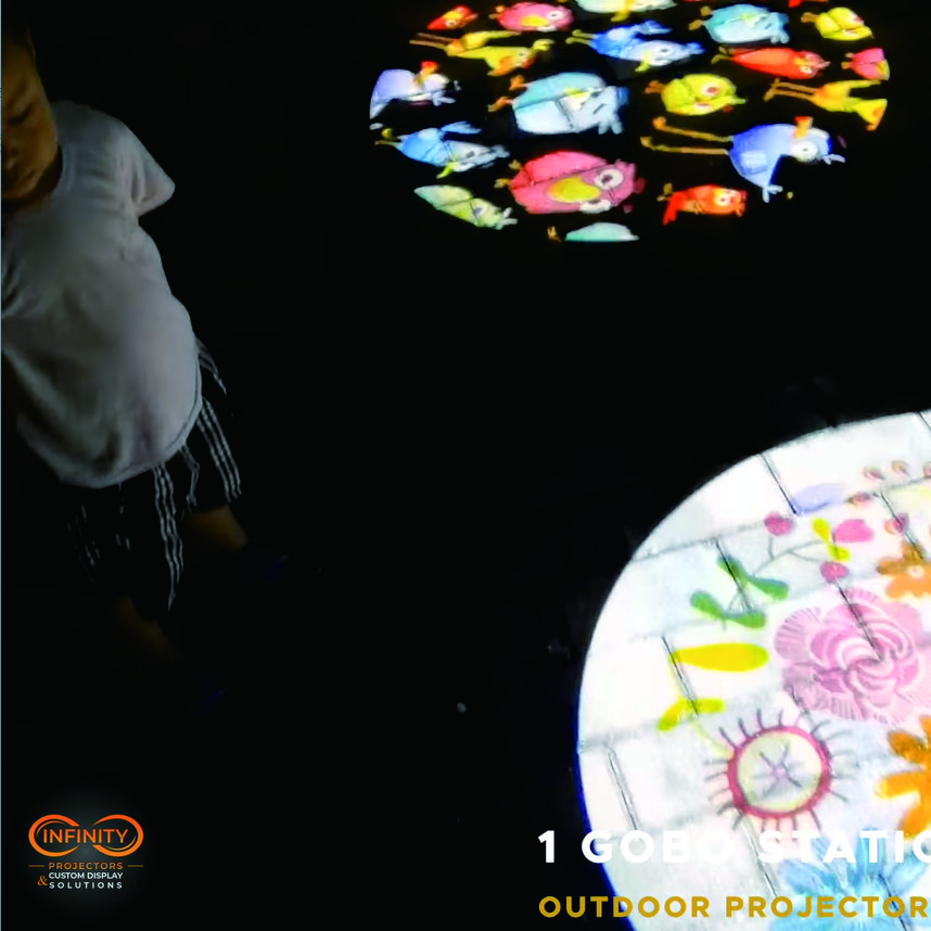 Video: colorful cartoon bird and flower gobos glow on dark patio pavers as a child plays nearby