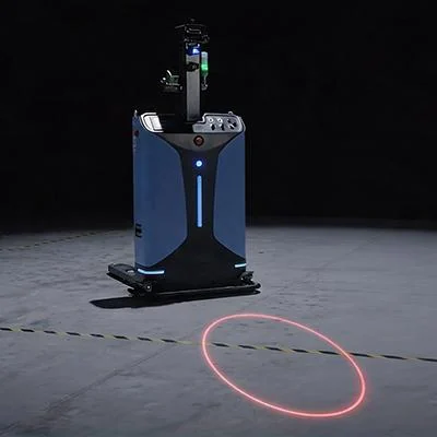 A blue AGV projecting a red laser circle on a dark floor around its work zone — Infinity Projectors