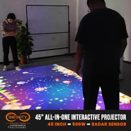 Video: two guests stand on a vivid starburst pattern beamed onto a showroom floor by an all-in-one projector
