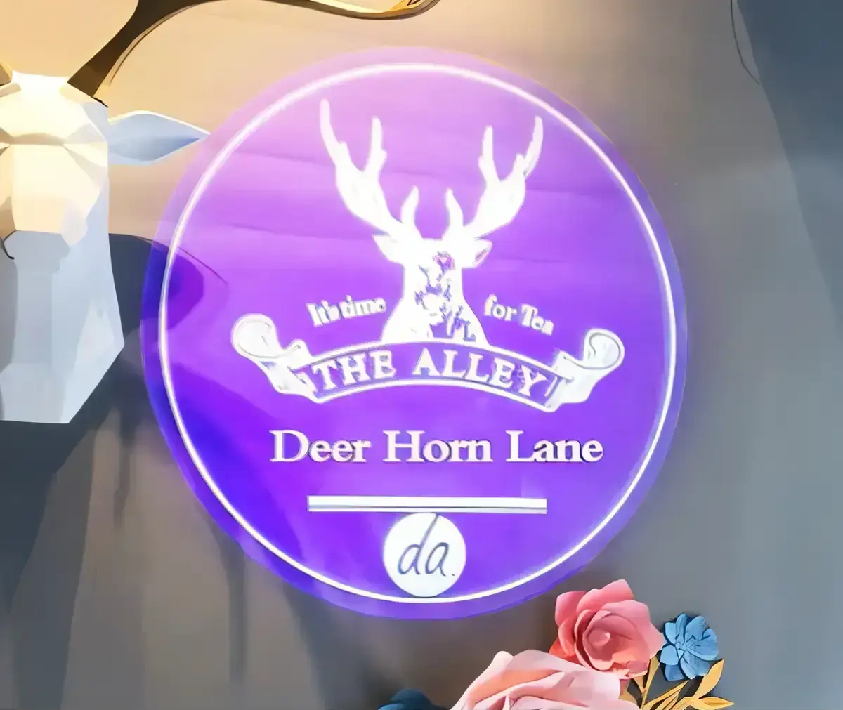 Purple circular tea-shop logo with a deer emblem projected on a boutique wall, a custom gobo in full color — Infinity Projectors