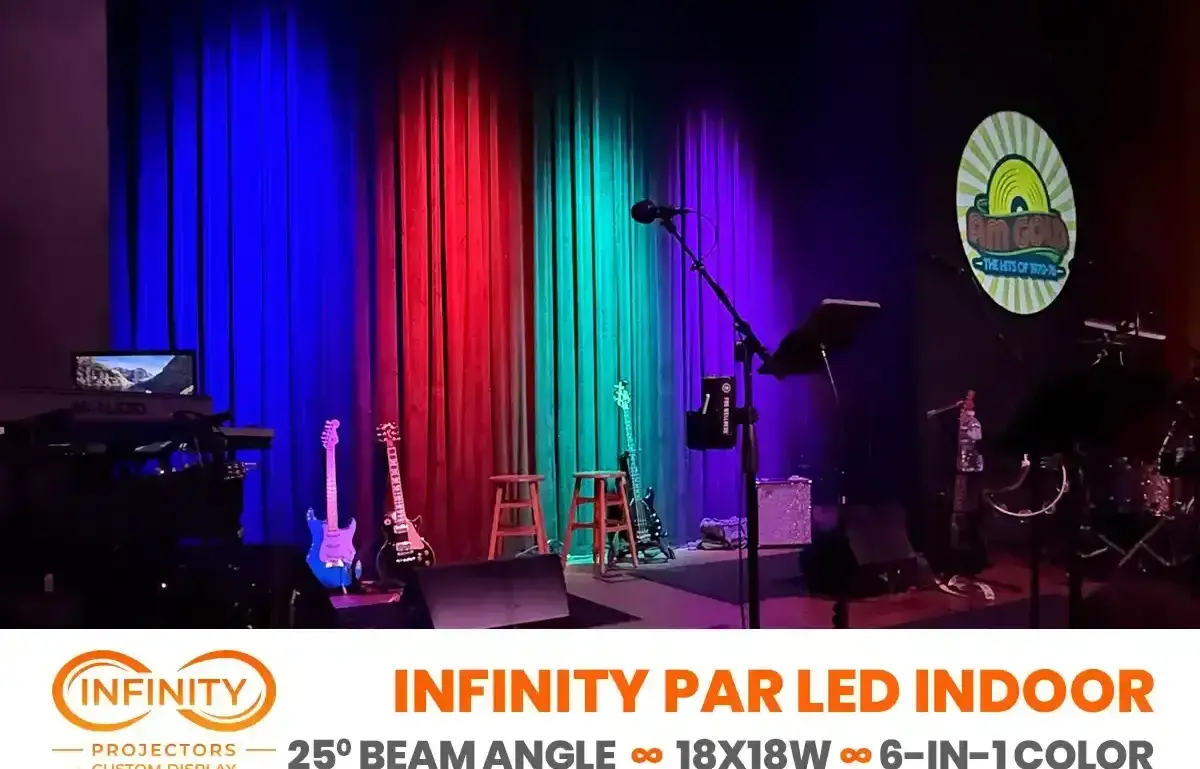 Club stage curtains lit blue, red and green, with guitars waiting and a retro sunburst band logo projected on the wall — Infinity Projectors