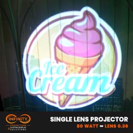 Video: pastel ice cream cone sign projected onto a striped storefront wall at night — Infinity Projectors