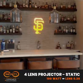 Video: yellow interlocking-letter monogram gobo lights a home bar wall lined with bottle shelves
