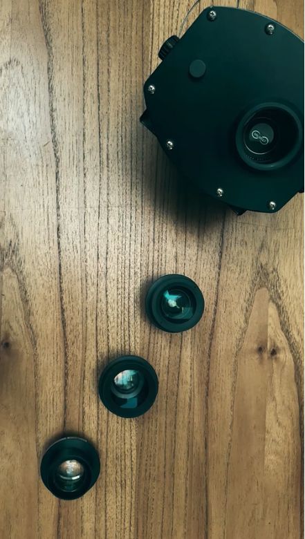 Video: overhead look at a gobo projector and three interchangeable lenses laid out on a wood floor