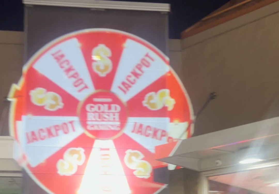 Video: red and white jackpot prize wheel projected on a gaming venue wall at night