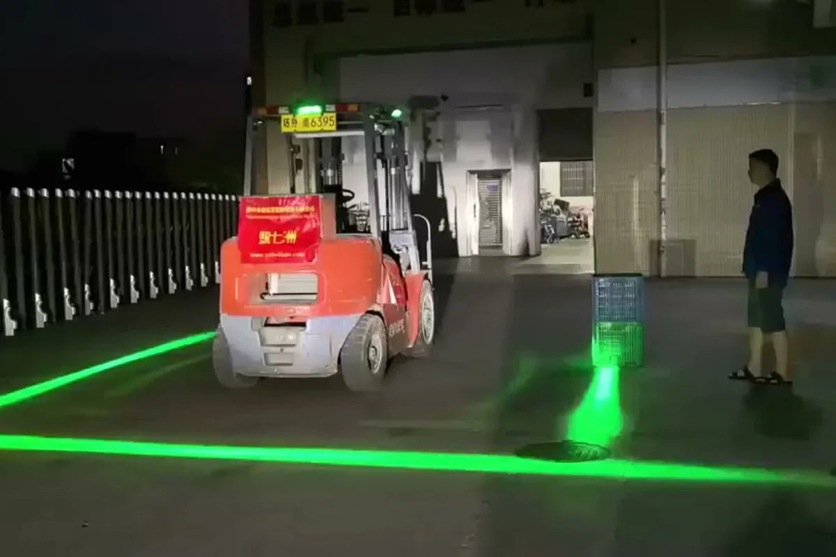 Forklift driving through a warehouse with green safety boundary lines projected on the floor around it — Infinity Projectors