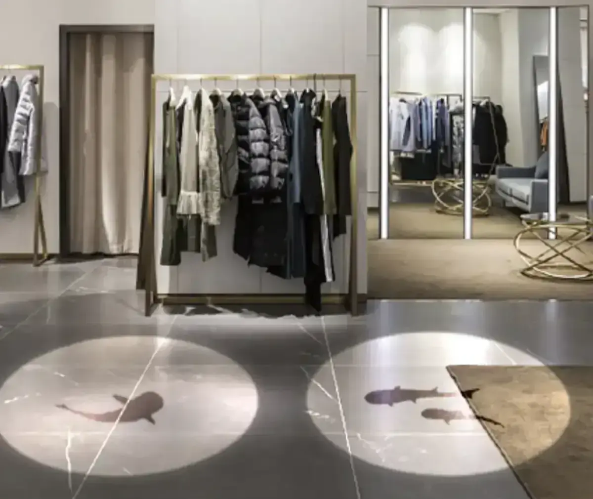 Twin spotlight circles with koi silhouettes on a clothing boutique's marble floor from small gobo projectors