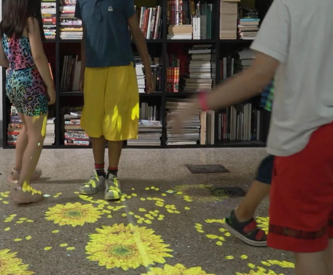 Real photo of flower pattern projected, people's feet visible — Infinity Projectors